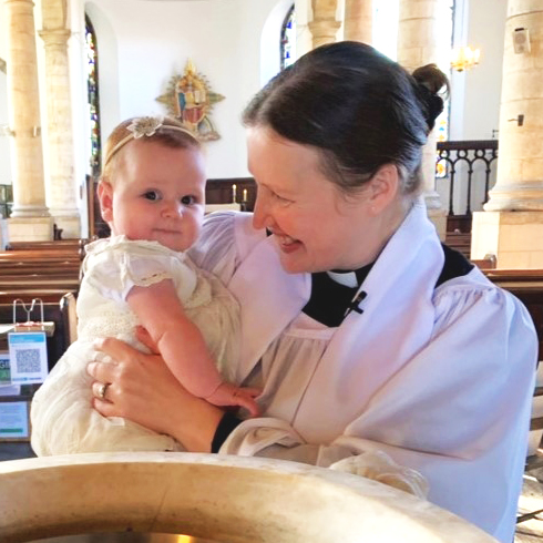 A baby, priest, and font